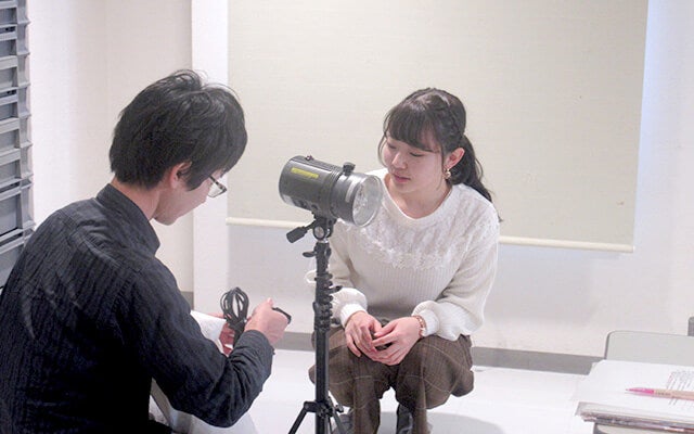 機材の説明をするカメラマンと佐藤さん