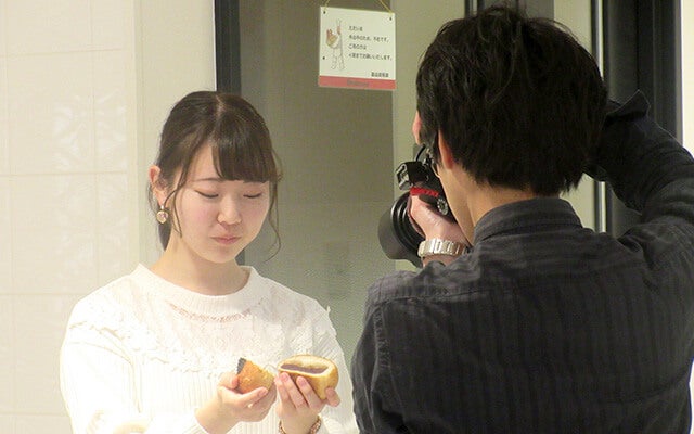 パンを手に取る佐藤さん