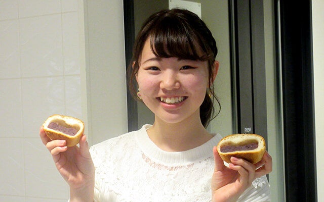半分になったパンを持って笑顔で映る佐藤さん