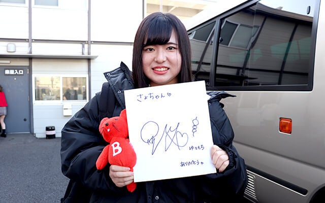 サイン色紙と共に記念撮影する青木さん