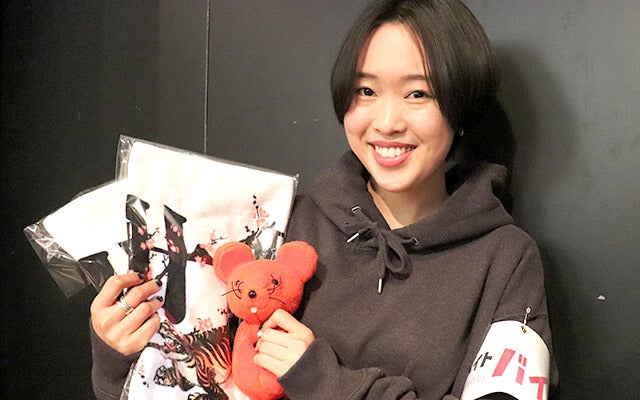 グッズと共に記念撮影する小栁さん