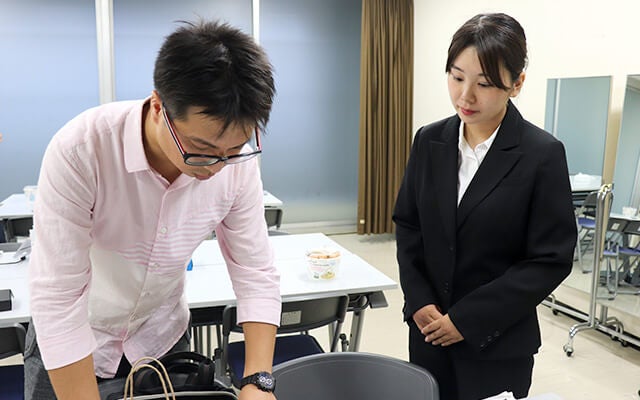 スタッフさんから説明を受ける田中さん