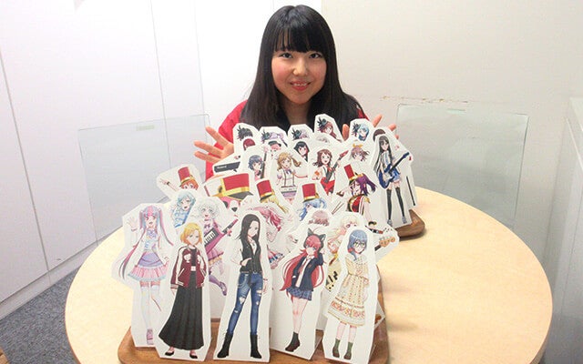 綺麗に並べたスタンドポップと一緒に写る鈴木さん