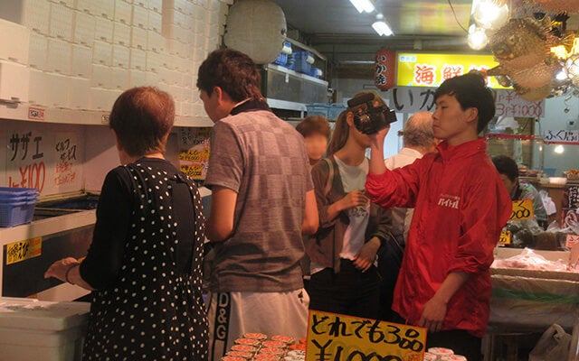 お店の人と会話しながら食材を選ぶきまぐれクックさんを撮影する藤倉さん