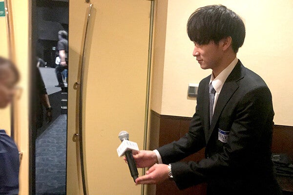 スタッフさんとマイクを渡す練習をする高野さん