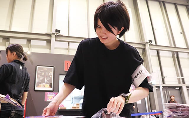 フライヤーを袋詰めする採用者