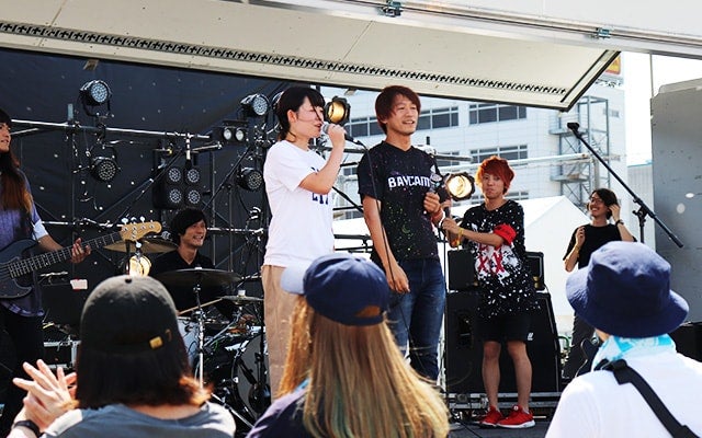 アーティストを呼び込む穐本さん写真