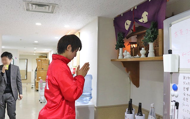 神棚に向かって二礼二拍手一礼をする山口君