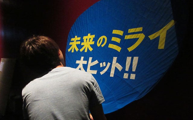 採用者が巨大な団扇を渡す様子