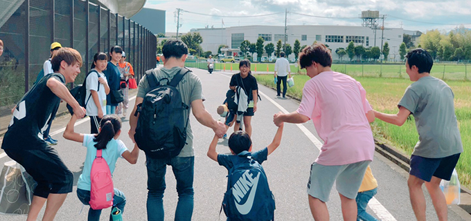 スタッフと手をつなぐ子どもたち