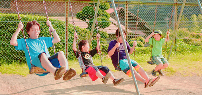 ブランコに乗るスタッフと子どもたち