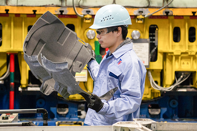 工場内で自動車部品の製造業務を行っている岡本さん