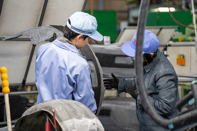 工場内で班長が新人に仕事を教えている様子