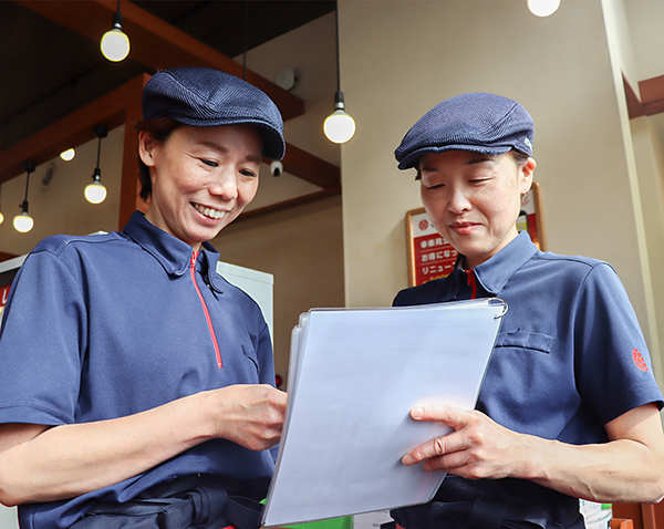 マニュアルを見ながら研修を行う主婦Oさんと店長Yさん
