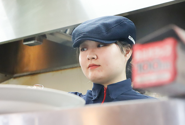 正しい身だしなみでキッチン業務をしている学生Nさん