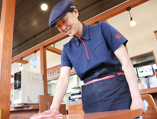テーブルを拭いている店長Yさん