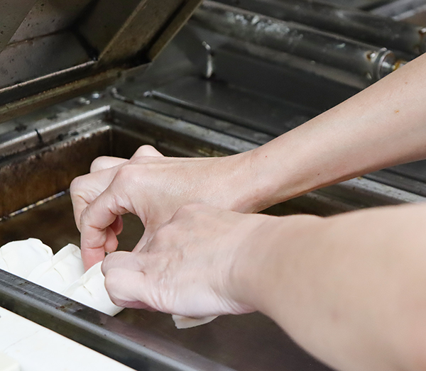 自動餃子焼き機に冷凍餃子をセットしている様子