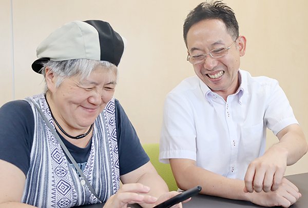 アプリの使い方を教える支店長Kさんと登録スタッフMさん