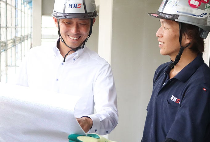 仕事内容を確認する統括部長のHさんと新人社員のYさん