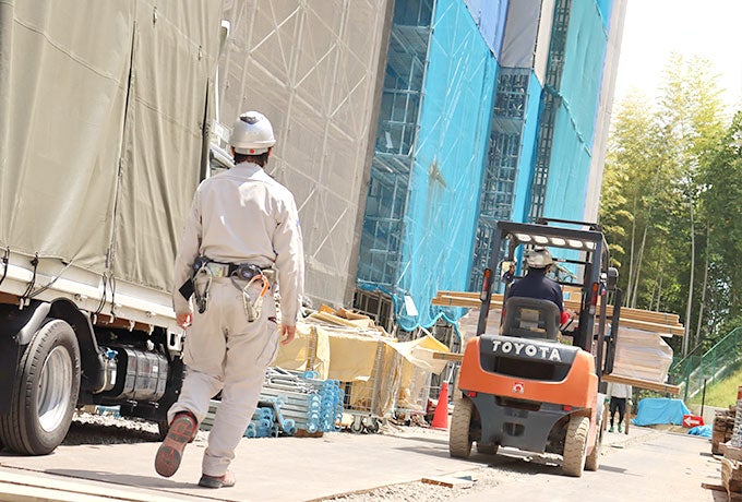 フォークリフトを運転する社員と安全点検を行う現場責任者