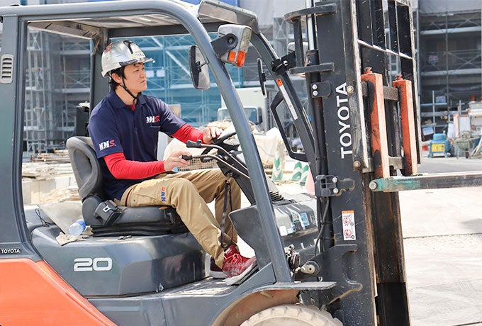 フォークリフトを操作し、資材を運搬する現場社員