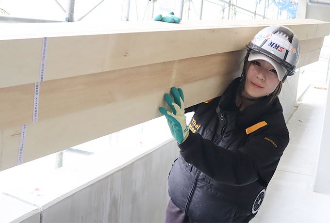 長く重い資材を運ぶ社員のKさん