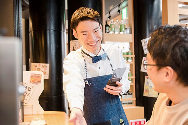 笑顔で接客している学生スタッフ