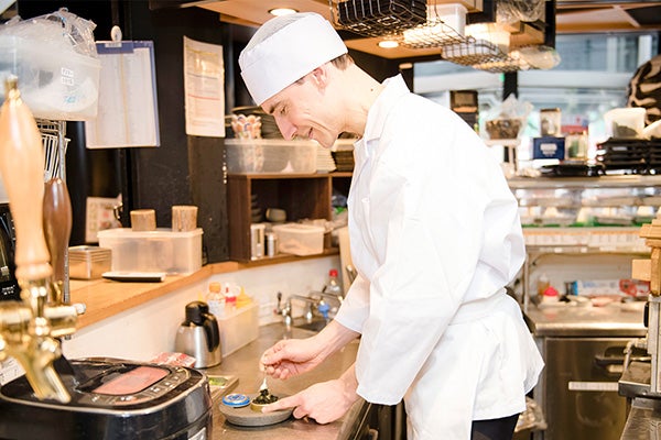 料理の盛り付けをしている外国籍スタッフ
