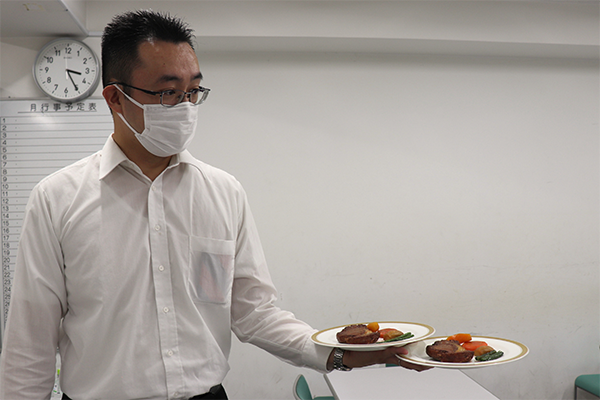 配膳のコツを実践しながら教えてくれる、ASANO GROUPの研修講師