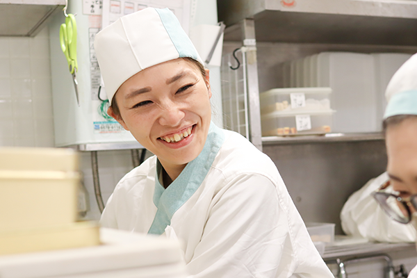 アルバイトスタッフの隣で笑顔で教えている店長Nさん