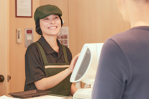 笑顔でレジ対応している女性スタッフ