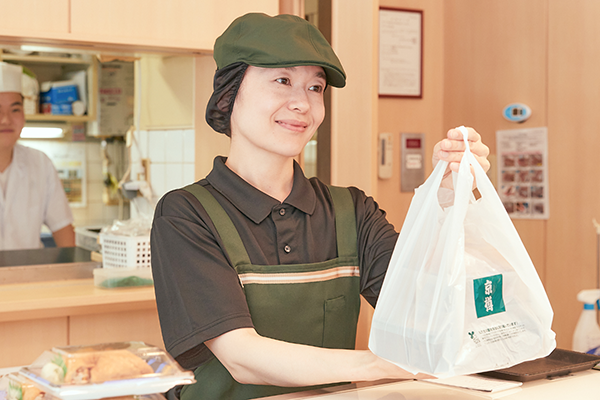 笑顔で接客している主婦スタッフ