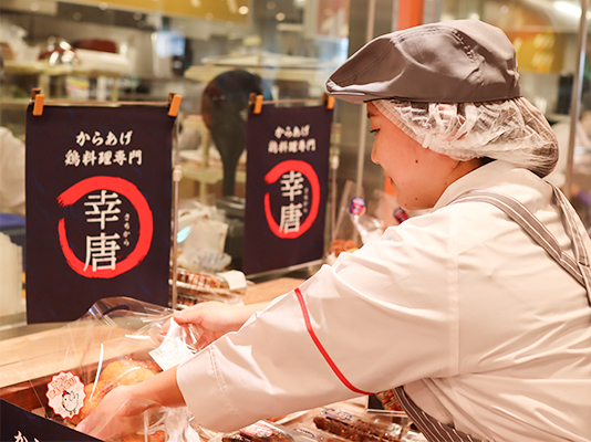 惣菜コーナーで売り方を考えながら働くパートのSさん