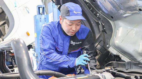 真剣な表情で車両整備をしているMさん