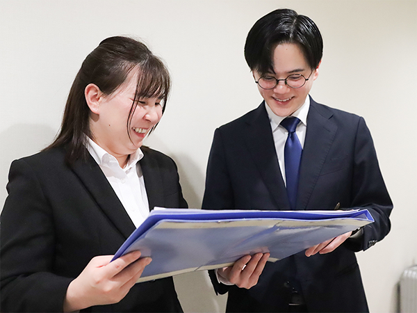 ホテルのフロントスタッフが引継ぎを受ける様子